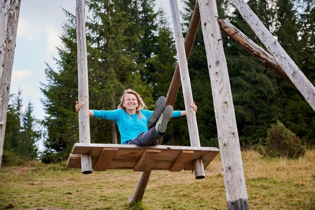 Balanceándose en una atracción gigante de madera al aire libre en verano