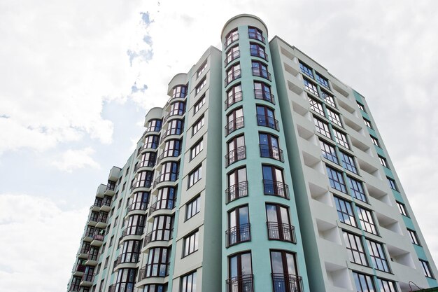 Balcón de un nuevo y moderno edificio residencial turquesa de varios pisos en una zona residencial en un cielo azul soleado