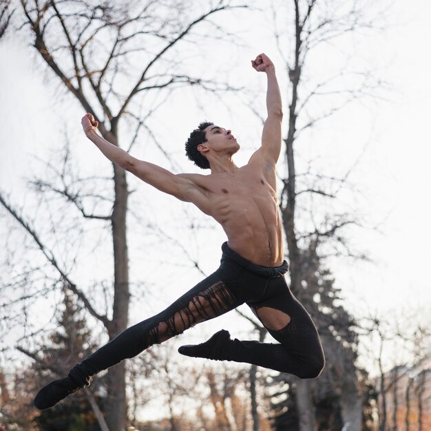 Ballet de baile masculino joven de ángulo bajo