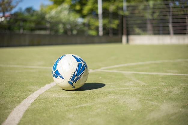 Balón de fútbol en el campo deportivo. Balón de fútbol azul y blanco en un campo desierto. Fútbol, deporte, concepto de actividades de ocio.