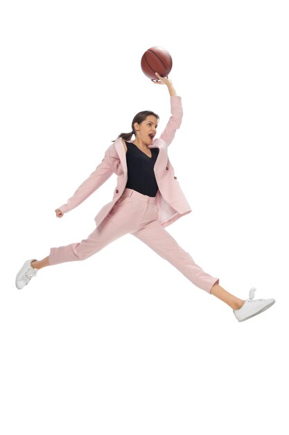 Baloncesto. Mujer joven feliz bailando con ropa informal o traje, rehaciendo movimientos legendarios y bailes de celebridades de la historia de la cultura. Aislado. Acción, movimiento, concepto de fama. Ocupación creativa.