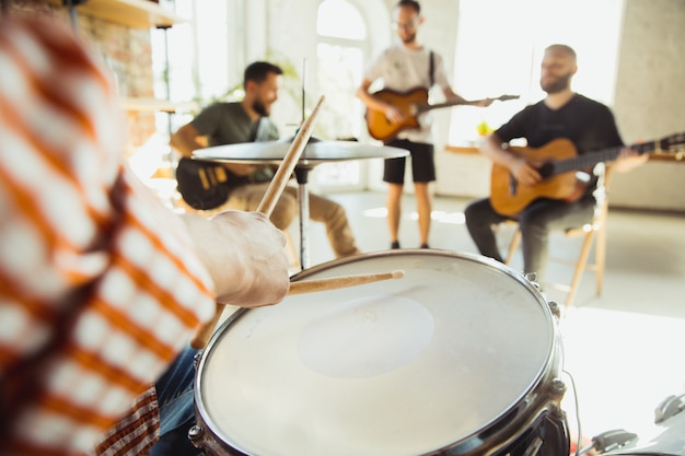 Banda de músicos improvisando juntos en el lugar de trabajo de arte con instrumentos