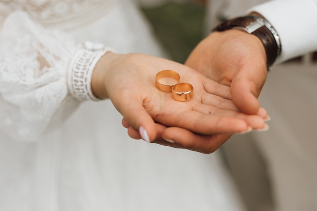 Bandas doradas en manos del novio y la novia.