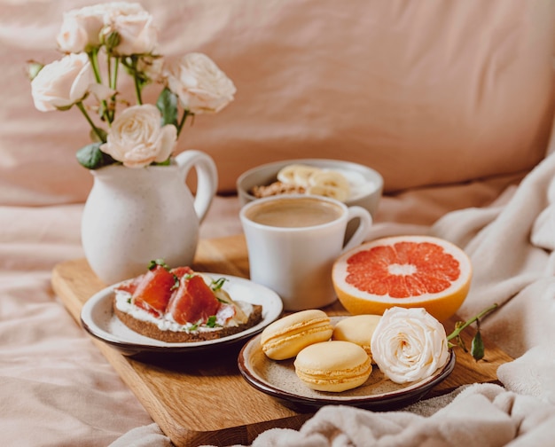 Bandeja con café matutino y sándwich en la cama