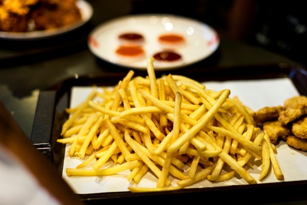 Bandeja de comida chatarra comida rápida nuggets de pollo y papas fritas