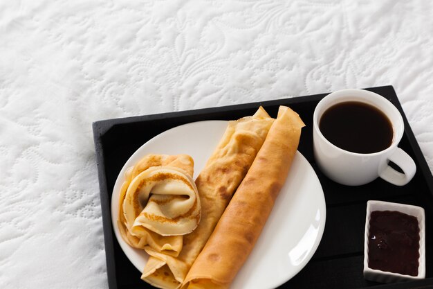 Bandeja de desayuno con café, panqueques y jarabe