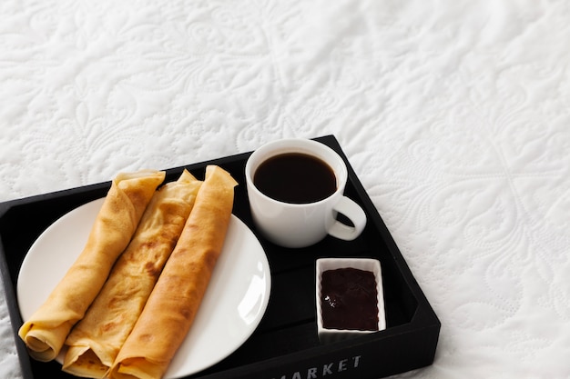 Bandeja de desayuno con café, panqueques y jarabe