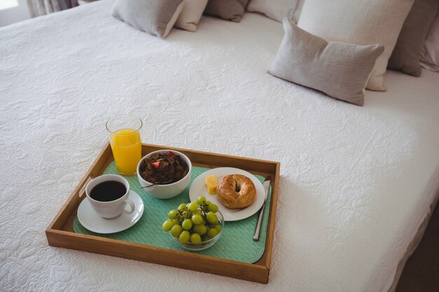 Foto gratuita bandeja de desayuno en cama en dormitorio