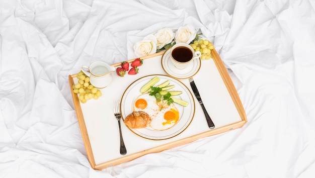 Bandeja de desayuno de la mañana en la sábana arrugada