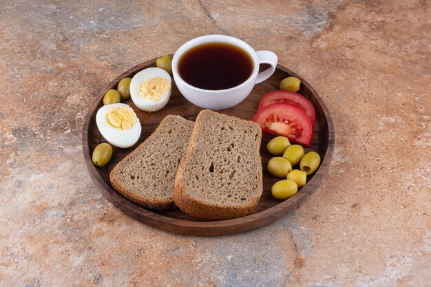 Bandeja de desayuno con pan y una taza de té.