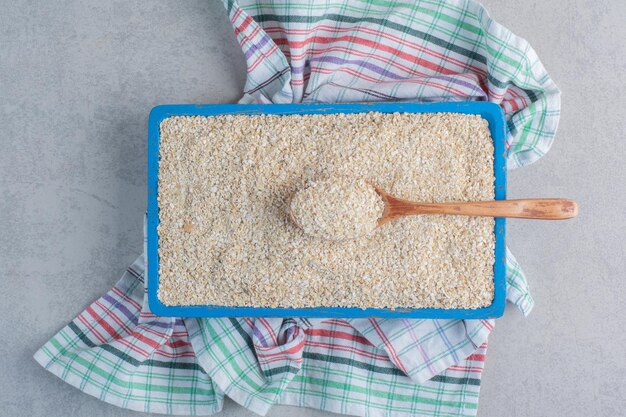 Una bandeja llena de arroz sobre una toalla sobre la superficie de mármol