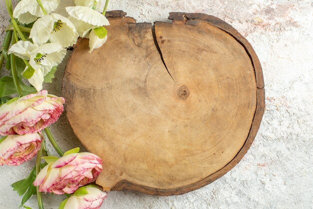 Bandeja de madera y flores sobre fondo de mármol blanco