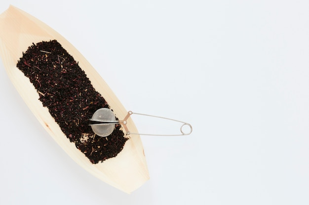 Bandeja de madera con hojas de té y espacio de copia