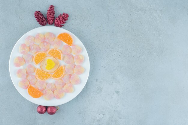 Bandeja de mermeladas variadas, con piñas y chucherías sobre mármol.