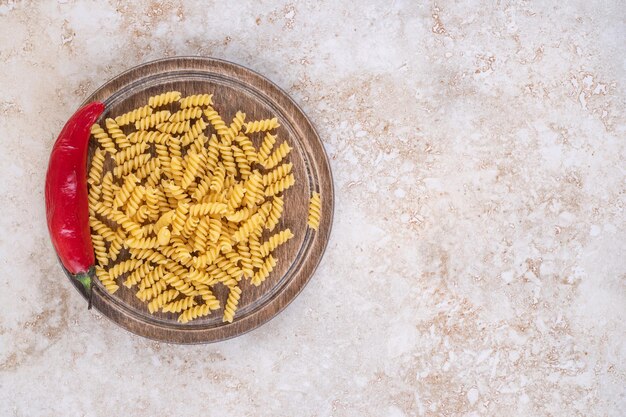 Bandeja de pasta cruda con ají sobre superficie de mármol