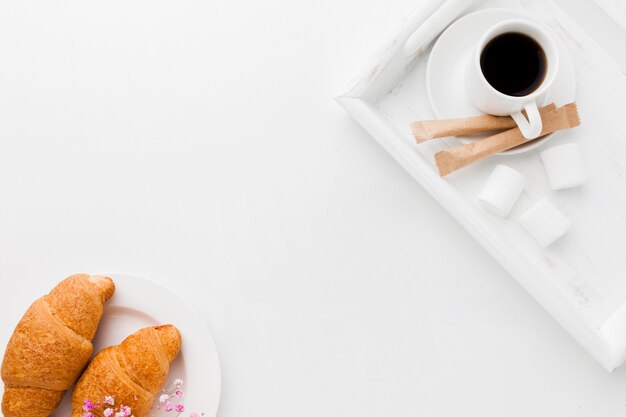 Bandeja con taza de café y croissant.