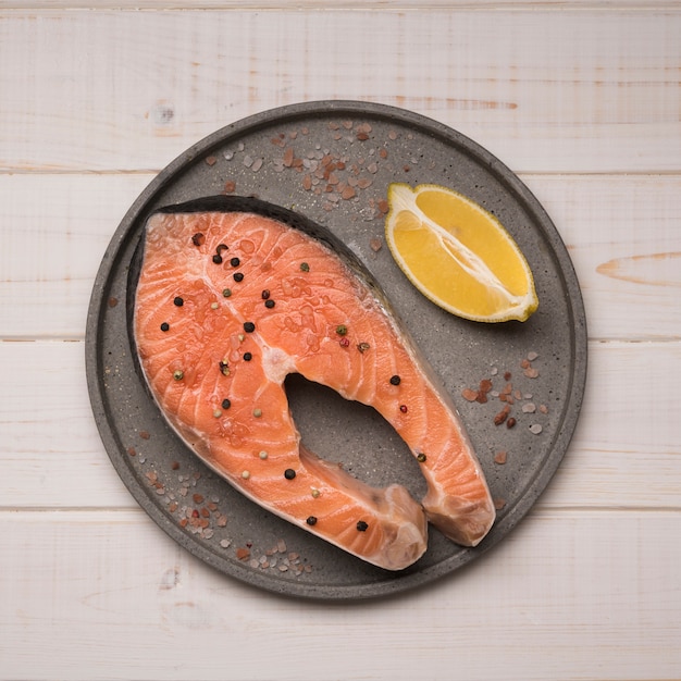 Foto gratuita bandeja de vista superior con filete de salmón crudo y limón