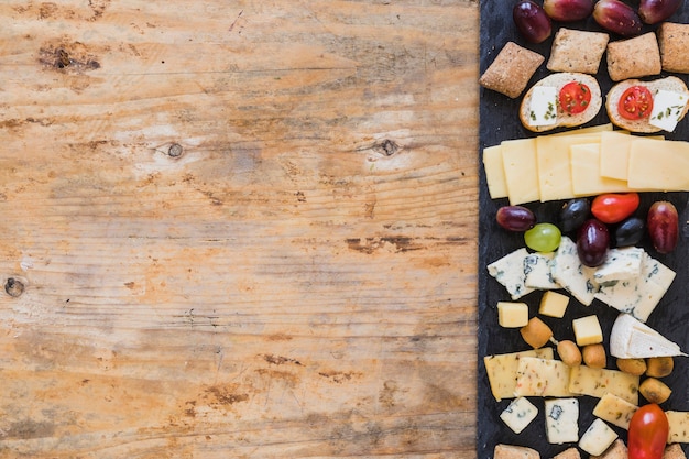 Foto gratuita bandejas de queso en pizarra negra sobre la mesa