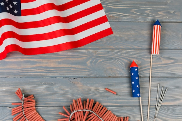 Bandera americana y fuegos artificiales de vacaciones sobre fondo de madera