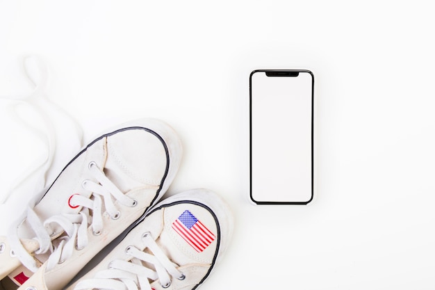 Bandera americana en zapatos al lado de smartphone