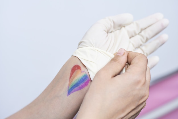 Bandera colorida del orgullo en forma de corazón en la mano de una persona