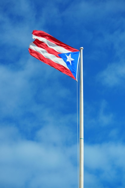 Foto gratuita la bandera del estado de puerto rico vuela con el cielo azul en san juan.