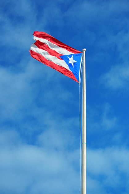 La bandera del estado de Puerto Rico vuela con el cielo azul en San Juan.