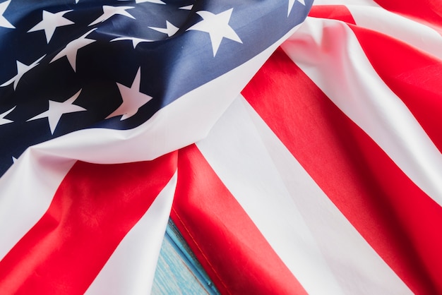 Bandera de Estados Unidos arrugado en superficie de madera azul