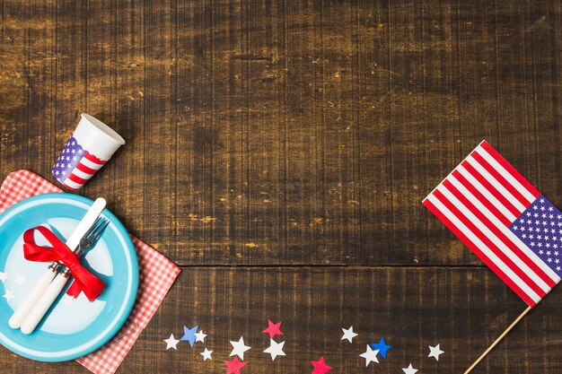 La bandera estadounidense y las estrellas de fieltro decoran la mesa con una placa azul en la mesa de madera