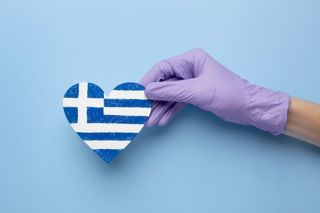 Bandera de grecia en forma de corazón sostenida en las manos