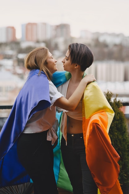 Bandera LGBT cerca de las niñas. Niñas de orientación no tradicional. Abrazos de lesbianas.