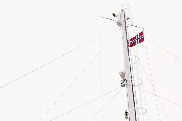 Bandera de Noruega en el viento bajo el cielo blanco