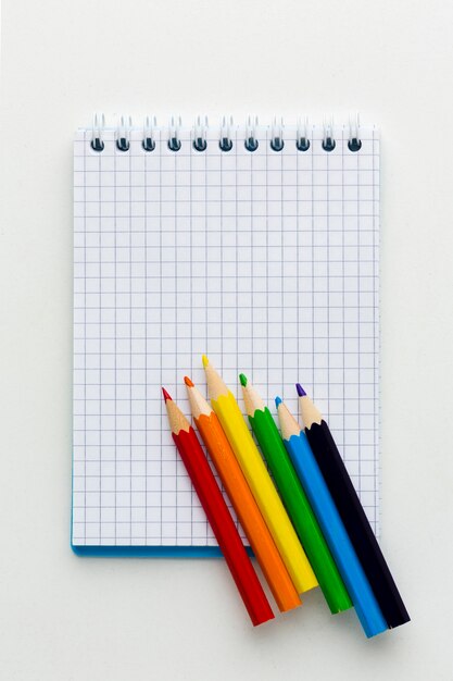 Bandera del orgullo del arco iris hecha de lápices y vista superior del bloc de notas