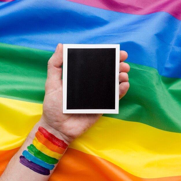 Bandera del orgullo del arco iris con mano y foto retro