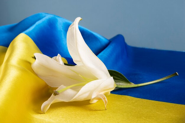 Bandera de ucrania de ángulo alto y naturaleza muerta de lirio