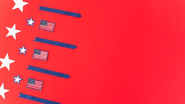 Banderas nacionales de estrellas y rayas sobre superficie roja.