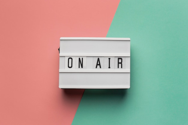 Foto gratuita banner en el aire para estación de radio sobre fondo rosa y azul claro