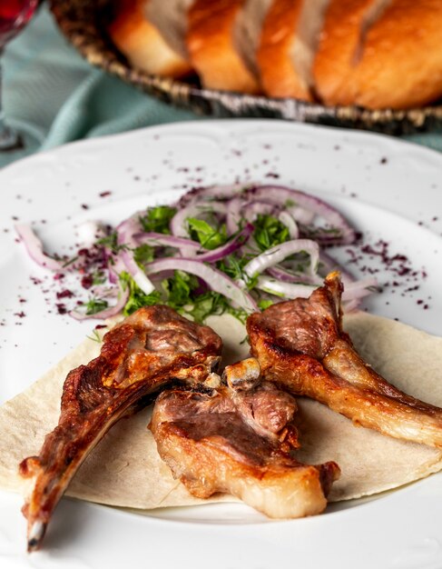 Barbacoa de hueso de ternera con ensalada verde de cebolla y especias.