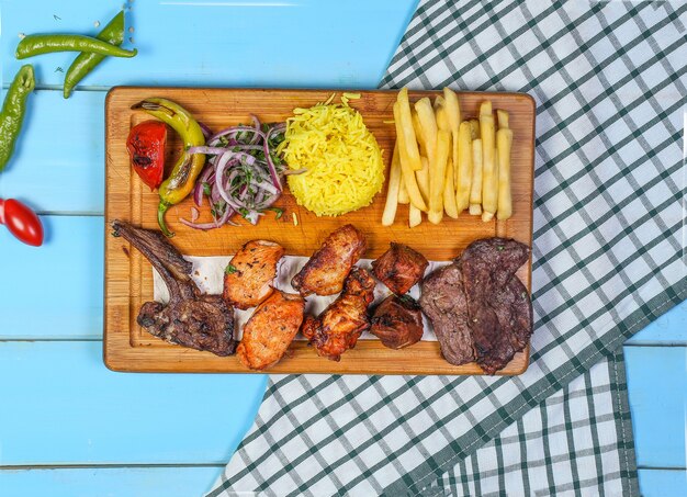 Barbacoa de pollo y carne con arroz y ensalada de verduras.