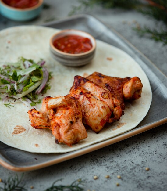 Barbacoa de pollo en lavash con ensalada de hierbas y salsa barbacoa.