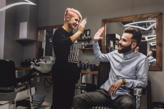 Barber y cliente dando alta cinco