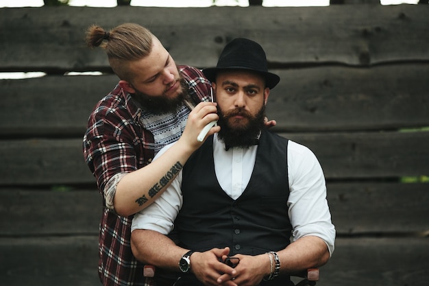 Barbero afeita a un hombre barbudo en ambiente vintage