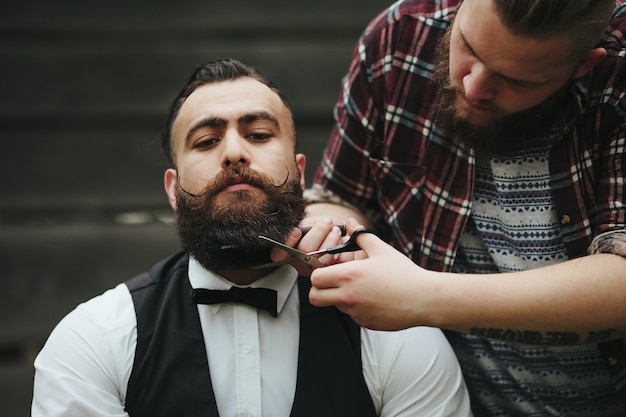 Barbero afeita a un hombre barbudo en ambiente vintage