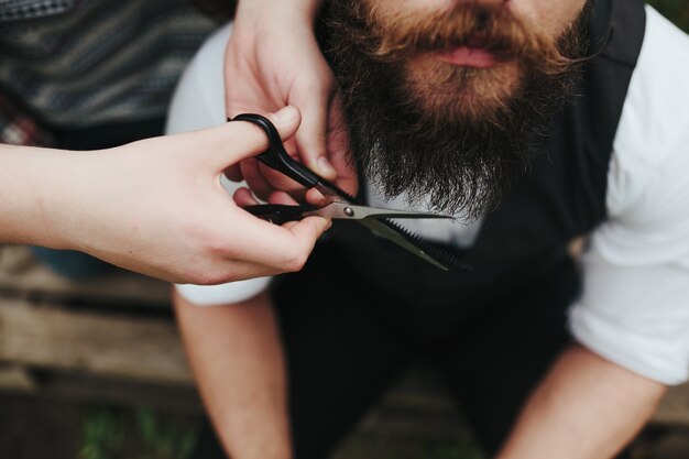 Barbero cortando una barba con tijeras