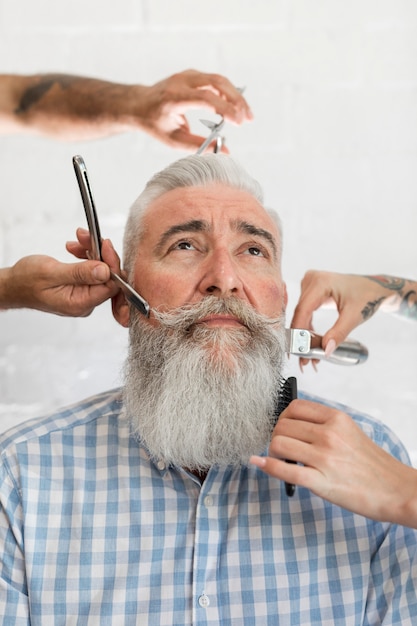 Barbero hombre envejecido visitando la peluquería