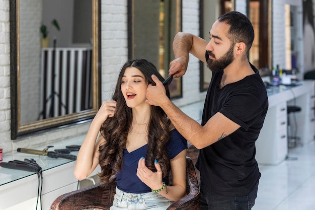 El barbero intentando cortar el pelo largo de su cliente