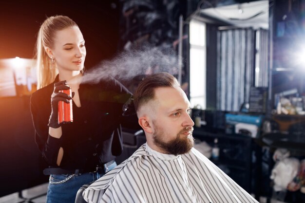 barbero mujer haciendo corte en barbería