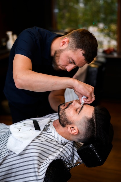 Barbero recortando la barba de un hombre