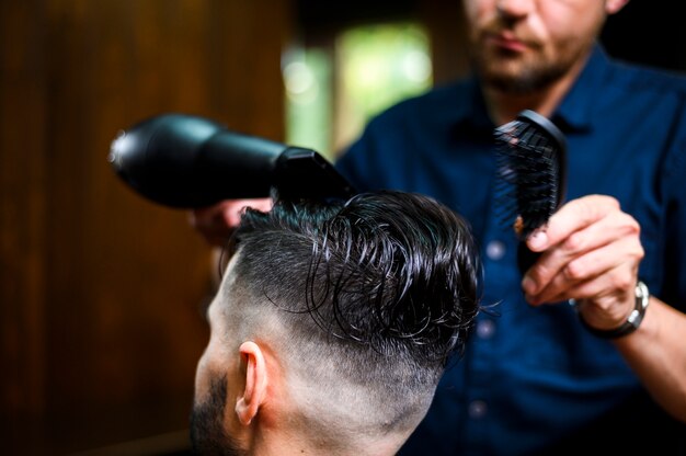 Barbero secando el cabello de su cliente