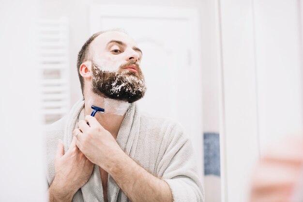 Barbudo afeitado en bata de baño